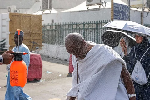 Relawan menyemprotkan air kepada jemaah haji  yang berjalan usai melakukan ibadah jumroh  sebagai bagian dari ibadah haji di Mina, Rabu (27/05/2026).
