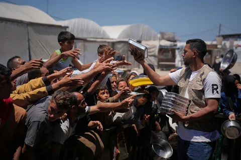Warga Palestina menerima sumbangan makanan di pusat distribusi di Khan Younis, Jalur Gaza, Rabu (27/95/2026).