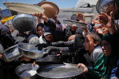 Warga Palestina  antri menerima sumbangan makanan di pusat distribusi di Khan Younis, Jalur Gaza, Rabu (27/95/2026).
