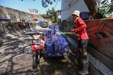 Pedagang mengisi dirigen dengan air yang akan dijual kepada warga di kawasan Muara Angke, Jakarta, Kamis (28/05/2026).
