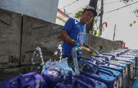 Pedagang mengisi dirigen dengan air yang akan dijual kepada warga di kawasan Muara Angke, Jakarta, Kamis (28/05/2026).