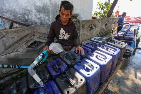 Pedagang mengisi dirigen dengan air yang akan dijual kepada warga di kawasan Muara Angke, Jakarta, Kamis (28/05/2026).
