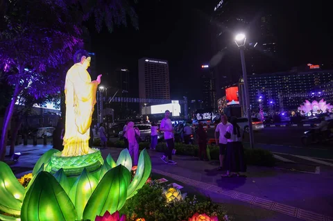 Warga berjalan di dekat ornamen lampu hias saat llumination of Jakarta: Glow of Peace di kawasan Bundaran HI, Jakarta, Kamis (28/5/2026).