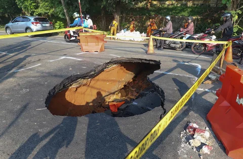 Pengendara bermotor melintas pada jalan yang ditutup sebagian  akibat jalan yang amblas di Jalan Raya Lenteng Agung, Jakarta Selatan, Jumat (29/5/2026).