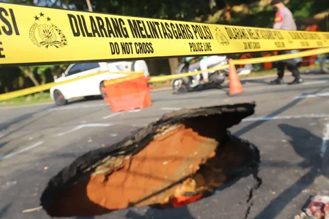 Pengendara bermotor melintas pada jalan yang ditutup sebagian  akibat jalan yang amblas di Jalan Raya Lenteng Agung, Jakarta Selatan, Jumat (29/5/2026).
