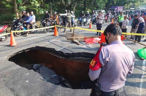 Pengendara bermotor melintas pada jalan yang ditutup sebagian  akibat jalan yang amblas di Jalan Raya Lenteng Agung, Jakarta Selatan, Jumat (29/5/2026).