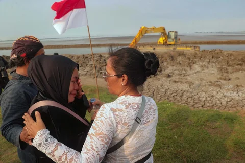 Warga korban Lumpur Lapindo menangis usai melakukan ritual Sambang Buyut untuk memperingati 20 tahun bencana Lumpur Lapindo di tanggul penahan lumpur Porong, Sidoarjo, Jawa Timur, Jumat (29/5/2026).