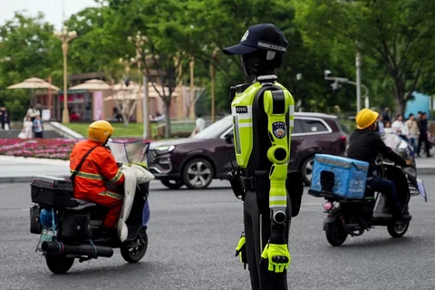 Kendaraan bermotor melewati robot polisi humanoid di Hangzhou, provinsi Zhejiang timur Tiongkok, Minggu (03/05/2026