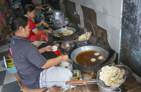 Pekerja menyelsaikan pembuatan kripik tempe di rumah usaha Keripik Tempe Mama Tina, Kebayoran Baru, Jakarta Selatan, Kamis (7/5/2026).