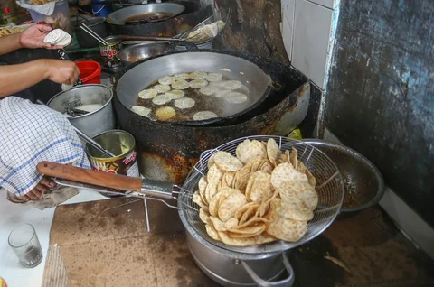 Pekerja menyelsaikan pembuatan kripik tempe di rumah usaha Keripik Tempe Mama Tina, Kebayoran Baru, Jakarta Selatan, Kamis (7/5/2026).