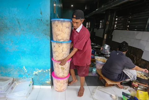 Pekerja menyelsaikan pembuatan kripik tempe di rumah usaha Keripik Tempe Mama Tina, Kebayoran Baru, Jakarta Selatan, Kamis (7/5/2026).