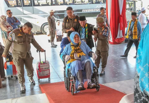 Petugas Satpol PP membantu jemaah haji saat  saat acara pelepasan jemaah di Aula Kantor Bupati, Kabupaten Bogor, Jawa Barat, Jumat (08/05/2026).