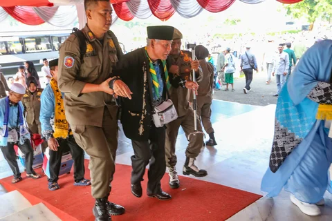 Petugas Satpol PP membantu jemaah haji saat  saat acara pelepasan jemaah di Aula Kantor Bupati, Kabupaten Bogor, Jawa Barat, Jumat (08/05/2026).