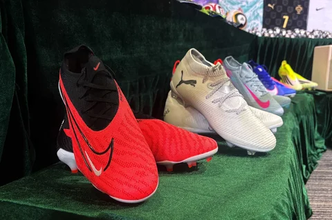 Sepatu sepak bola dipamerkan oleh otoritas bea cukai Hong Kong dalam konferensi pers tentang barang palsu dan barang yang melanggar hak cipta di kantor pusat mereka di North Point, Hong Kong, Kamis (11/06/2026).