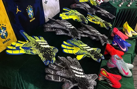 Sarung tangan dan sepatu sepak bola dipamerkan oleh otoritas bea cukai Hong Kong dalam konferensi pers tentang barang palsu dan barang yang melanggar hak cipta di kantor pusat mereka di North Point, Hong Kong, Kamis (11/06/2026).
