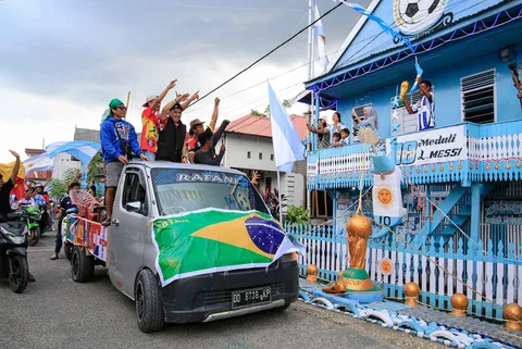 Ratusan warga Desa Pambusuang, Kecamatan Balanipa, Kabupaten Polewali Mandar, menggelar konvoi kendaraan sambil membawa atribut negara peserta untuk menyambut Piala Dunia 2026, Kamis (11/6/2026).