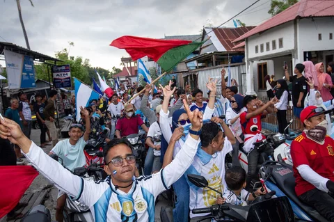 Ratusan warga Desa Pambusuang, Kecamatan Balanipa, Kabupaten Polewali Mandar, menggelar konvoi kendaraan sambil membawa atribut negara peserta untuk menyambut Piala Dunia 2026, Kamis (11/6/2026).