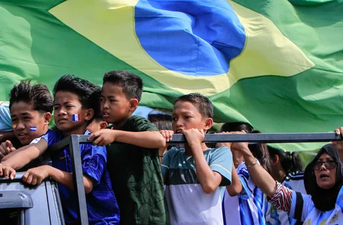 Warga Desa Pambusuang, Kecamatan Balanipa, Kabupaten Polewali Mandar  saat mengikuti konvoi kendaraan sambil membawa atribut negara peserta untuk menyambut Piala Dunia 2026, Kamis (11/6/2026).