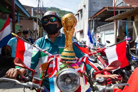 Warga Desa Pambusuang, Kecamatan Balanipa, Kabupaten Polewali Mandar  saat mengikuti konvoi kendaraan sambil membawa atribut negara peserta untuk menyambut Piala Dunia 2026, Kamis (11/6/2026).