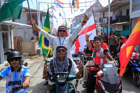 Ratusan warga Desa Pambusuang, Kecamatan Balanipa, Kabupaten Polewali Mandar, menggelar konvoi kendaraan sambil membawa atribut negara peserta untuk menyambut Piala Dunia 2026, Kamis (11/6/2026).