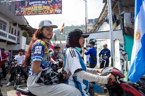 Warga Desa Pambusuang, Kecamatan Balanipa, Kabupaten Polewali Mandar  saat mengikuti konvoi kendaraan sambil membawa atribut negara peserta untuk menyambut Piala Dunia 2026, Kamis (11/6/2026).