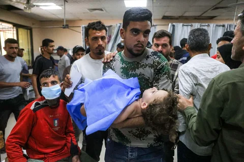 Seorang pria menggendong seorang anak yang terluka di ruang perawatan trauma di Kompleks Medis Nasser di Khan Yunis di Jalur Gaza Selatan, Senin (25/05/2026).
