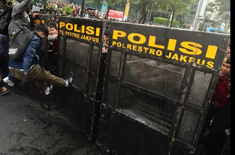 Mahasiswa mencoba  merobohkan pagar besi pembatas barikade saat bentrok dengan petugas  di Jalan MH. Thramrin, Jakarta, Jumat (12/06/2026).
