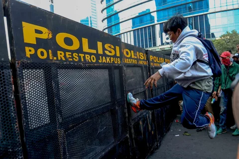 Pengunjuk rasa saling dorong dengan aparat keamanan saat aksi di Jalan MH Thamrin, Jakarta, Jumat (12/6/2026).