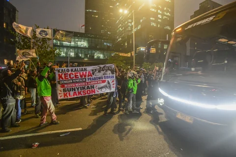 Pengunjuk rasa membentangkan spanduk meminta dukungan klakson kepada pengendara bermotor di Jalan MH. Thamrin, Jakarta, Jumat (12/06/2026).