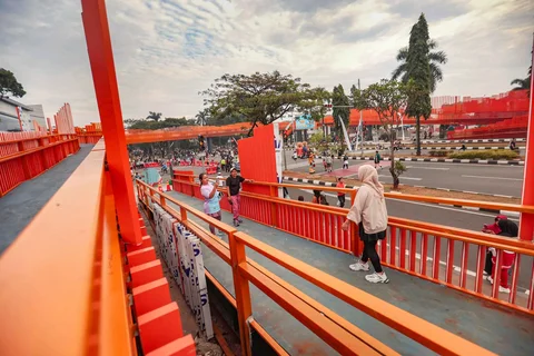 Warga beraktivitas pada Jembatan Penyeberangan Orang (JPO) Jalan Tegar Beriman, Cibinong, Kabupaten Bogor, Jawa Barat, Minggu (14/6/2026).