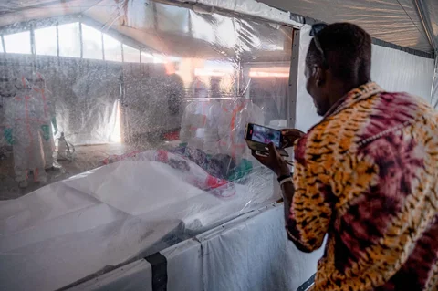 Anggota keluarga memberikan penghormatan terakhir kepada kerabat yang meninggal karena penyakit virus Ebola melalui jendela di kamar mayat Pusat Medis Evangelis Nyankunde di Bunia, Provinsi Ituri, Republik Demokratik Kongo,Sabtu (13/06/2026).