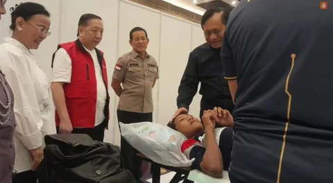Ketua Umum Yayasan Pundi Amal Peduli Kasih (YPP), Komjen Pol. (Purn.) Drs. Imam Sudjarwo, M.Si., berbincang hangat dengan seorang anak usai menjalani sunat massal, didampingi Presiden Direktur Pakuwon Group, Alexander Stefanus Ridwan (rompi merah)