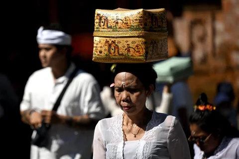 Seorang wanita Hindu membawa persembahan untuk merayakan merayakan Hari Raya Galungan di sebuah pura di Denpasar, Pulau Bali, Indonesia, Rabu (17/06/2026).