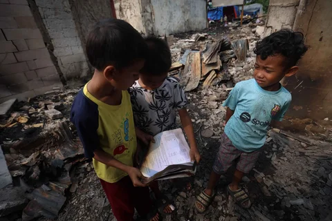 Anak-anak melihat buku yang terbakar di lokasi kebakaran permukiman penduduk di kawasan Kebon Kosong, Kemayoran, Jakarta, Selasa (02/06/2026).