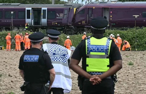 Petugas Kepolisian Transportasi Inggris berjaga di lokasi kecelakaan sementara tim Cabang Investigasi Kecelakaan Kereta Api melakukan penyelidikan terhadap tabrakan dua kereta East Midlands Railway (EMR) di selatan Bedford, Inggris tengah, Sabtu (20/06/2026).