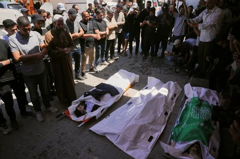 Warga Palestina berduka atas jenazah, dari kiri, Ahmed Wishah, seorang juru kamera Al Jazeera, Abdel Rahman Gharqoud, dan Saba'i Abu Hasna, seorang militan Hamas, yang tewas dalam serangan udara Israel, selama pemakaman mereka di Rumah Sakit Al-Aqsa di Deir al-Balah, Jalur Gaza, Minggu, (21/06/2026).