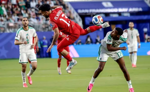 Pemain Yordania Mahmoud Almandi mencoba memukul bola ke depan pemain Aljazair Rafik Belghali  selama babak pertama pertandingan sepak bola Grup J Piala Dunia di Santa Clara, California, Amerika Serikat,  Senin (22/05/2026)..