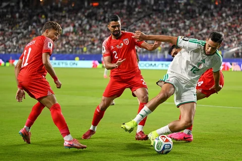 Pemain Aljazair Nadhir Benbouali berebut bola dengan pemain Yordania  Mohammad Abuhasheesh dan Odeh Fakhoury selama pertandingan sepak bola Grup J Piala Dunia di Santa Clara, California, dekat San Francisco, Senin (22/05/2026)..