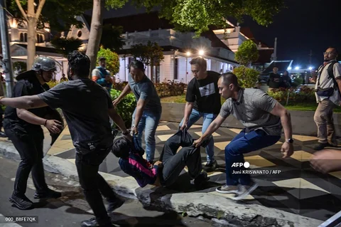 Petugas kepolisian saat menangkap pengunjuk rasa  di depan Gedung Grahadi Surabaya, Jumat malam (26/06/2026).