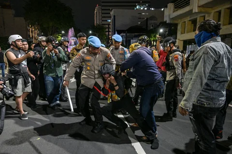 Petugas kepolisian saat menangkap pengunjuk rasa  di depan Gedung Grahadi Surabaya, Jumat malam (26/06/2026).