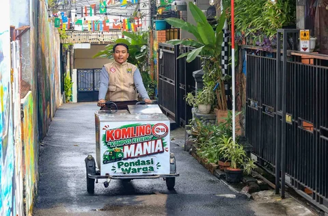 Petugas berkeliling  melayani warga yang membuang sampah organik pada gerobak listrik Komling (kompos keliling) di Rt  11/ 07, Gandarai Utara, Jakarta, Minggu (28/06/2026).