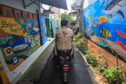 Petugas berkeliling  melayani warga yang membuang sampah organik pada gerobak listrik Komling (kompos keliling) di Rt  11/ 07, Gandarai Utara, Jakarta, Minggu (28/06/2026).