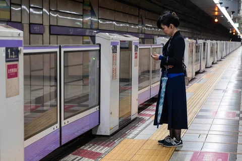 Seorang wanita menunggu kereta di peron yang kosong pada jam sibuk saat badai tropis hebat Jangmi melanda Tokyo,  Rabu (03/06/2026).