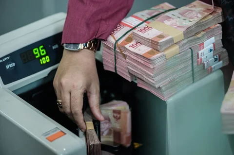 Uang kertas rupiah Indonesia dihitung oleh mesin penghitung uang di kantor penukaran mata uang di Jakarta,  Kamis (04/06/2026).