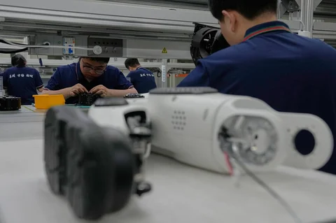 Para pekerja merakit komponen kaki robot di Pabrik Super LY iTech Beijing di Beijing E-Town di pinggiran Beijing, China (29/05/2026).