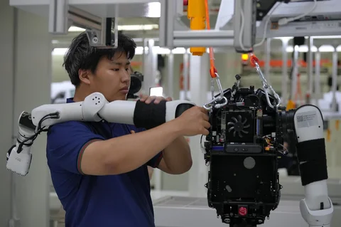 Para pekerja merakit komponen robot di Pabrik Super LY iTech Beijing di Beijing E-Town di pinggiran Beijing, China (29/05/2026).