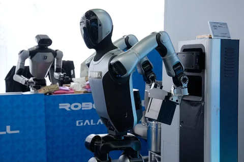 Sebuah robot mengganti baterai sendiri sementara robot lain menyortir paket di Pusat Inovasi Robotika Humanoid Beijing di Beijing E-Town di pinggiran Beijing, China (29/05/2026).