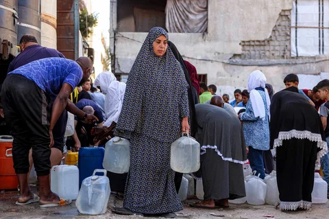 Para pengungsi perang antri menunggu mengambil air dari sebuah tangki air di kamp pengungsian di Khan Yunis di Jalur Gaza Selatan, Palestina, Sabtu (06/06/2026).