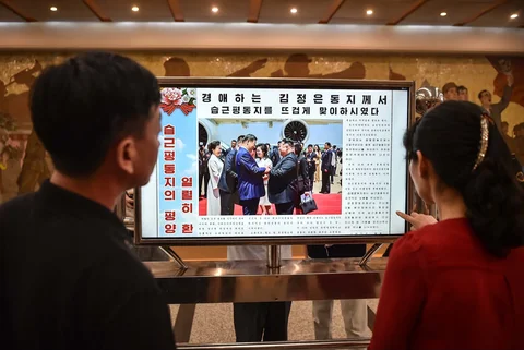 Orang-orang melihat layar yang menampilkan surat kabar "Rodongsinmun" yang memberitakan kunjungan Presiden Tiongkok Xi Jinping, di Stasiun Kaeson Metro Pyongyang di Pyongyang, Korea Utara, Selasa (09/06/2026).<br />AFP/ Kim Won Jin
