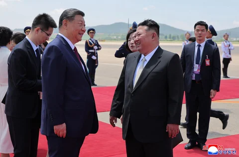 Pemimpin Korea Utara Kim Jong Un (kanan) menyambut Presiden Tiongkok Xi Jinping (kiri) saat kedatangannya di Bandara Pyongyang, Korea Utara, Senin (08/06/2026).
